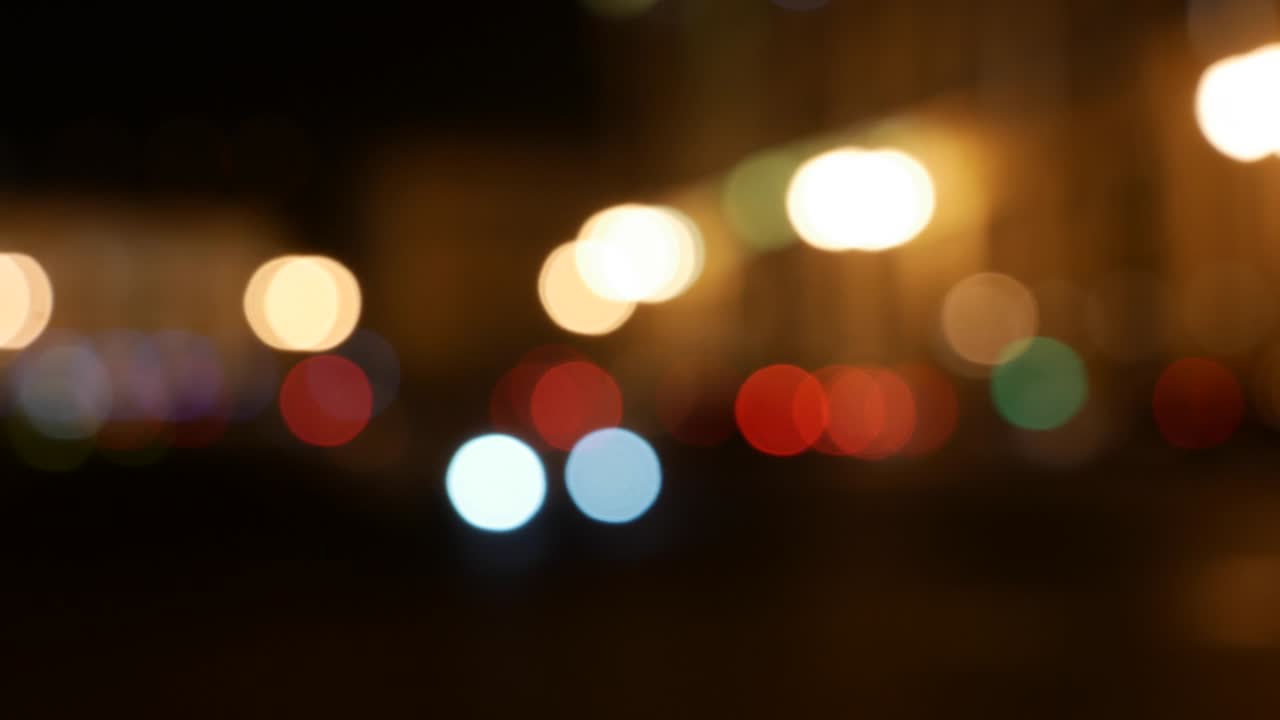 hermoso bokeh brillante en el fondo oscuro borroso por la noche. el redondo bokeh colorido brilla de las luces de los coches en la calle de la ciudad. fuera de foco con borroso. luces de la ciudad sin enfoque. bokeh de tráfico. concepto abstracto