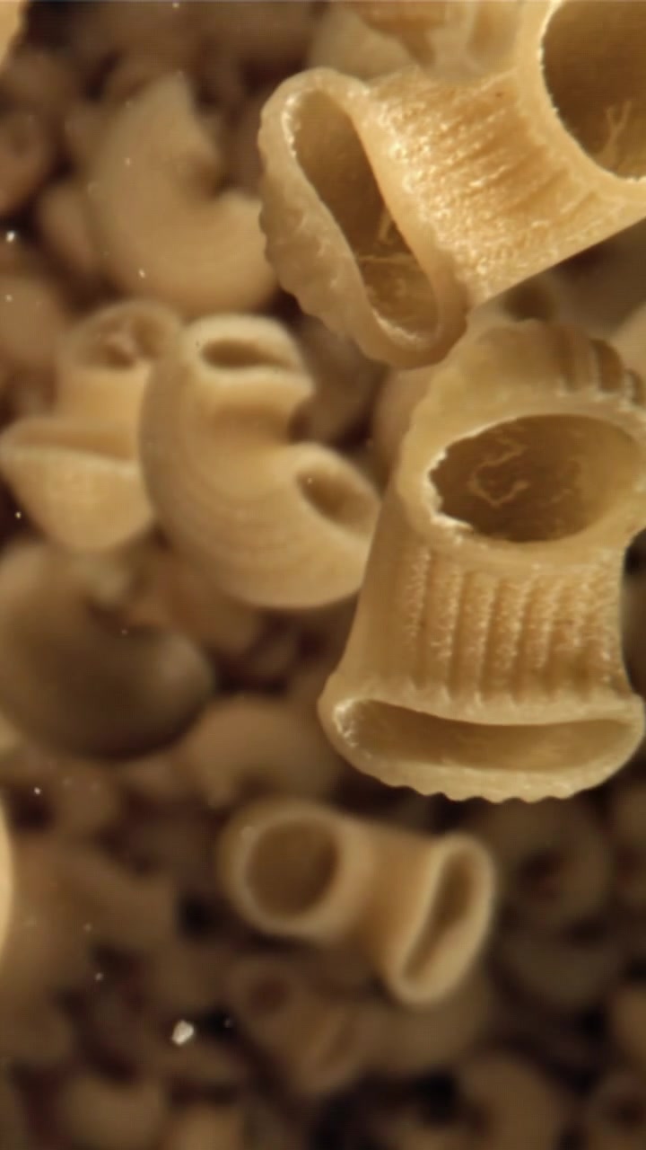 Primo piano di maccheroni che galleggiano in acqua