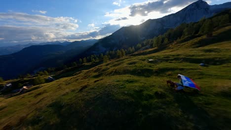 fpv footage was filmed in the slovenian mountain village in the alps with a drone flying fast over mountains filmed with a gopro with incredible surrounding landscapes with a hiker holding a flag-2