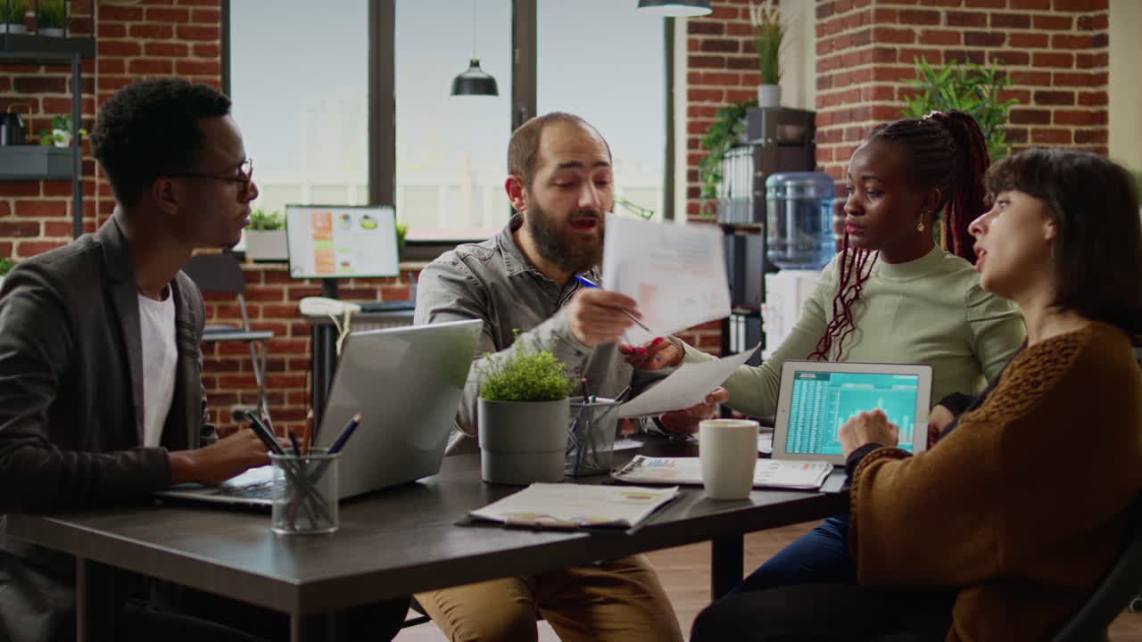Diverse team of coworkers analyzing business charts on documents