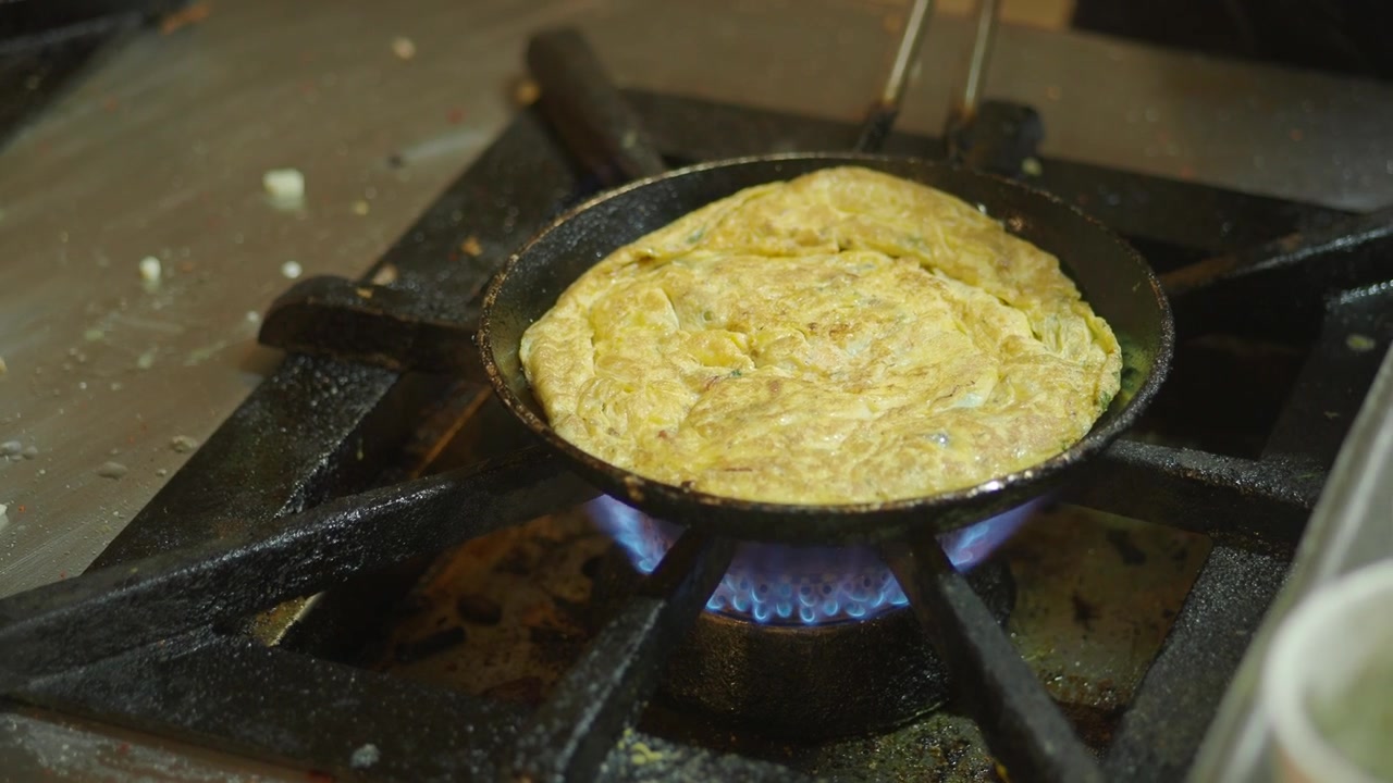 Omelet Cooking in a Frying Pan on a Gas Stove
