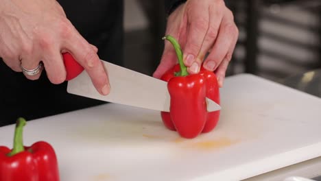 chef cutting a red bell pepper