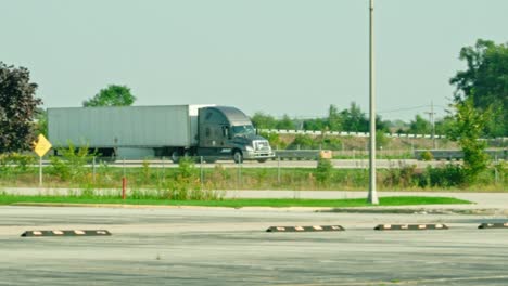 slow motion of a grey semi truck trailer driving on interstate