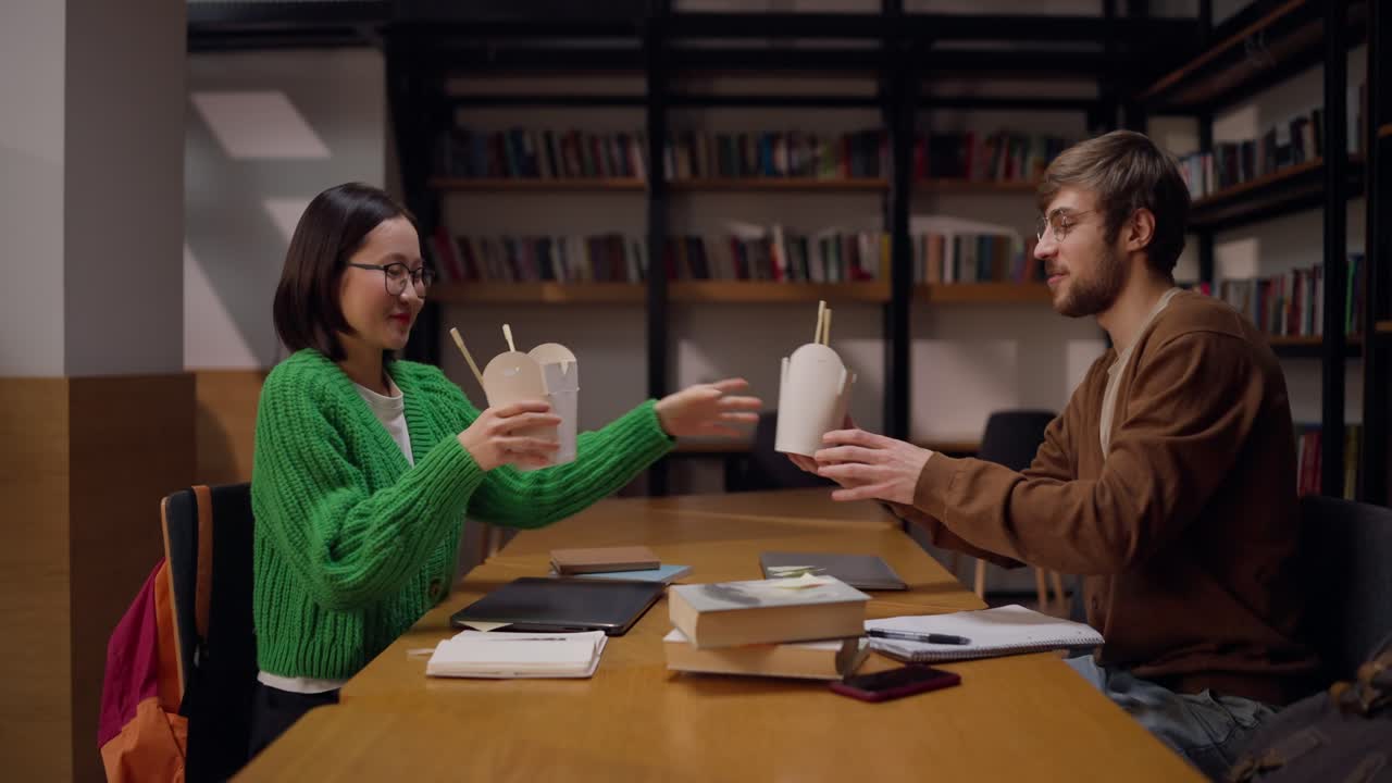 Studenti che studiano e pranzano in biblioteca
