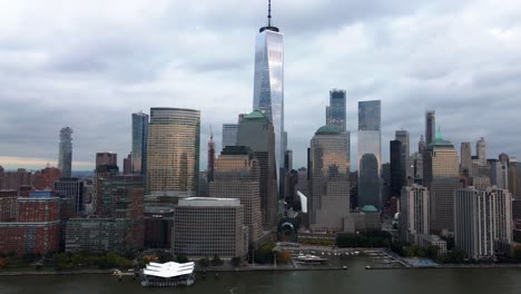 aerial drone view panning towards the one world trade center, in cloudy new york