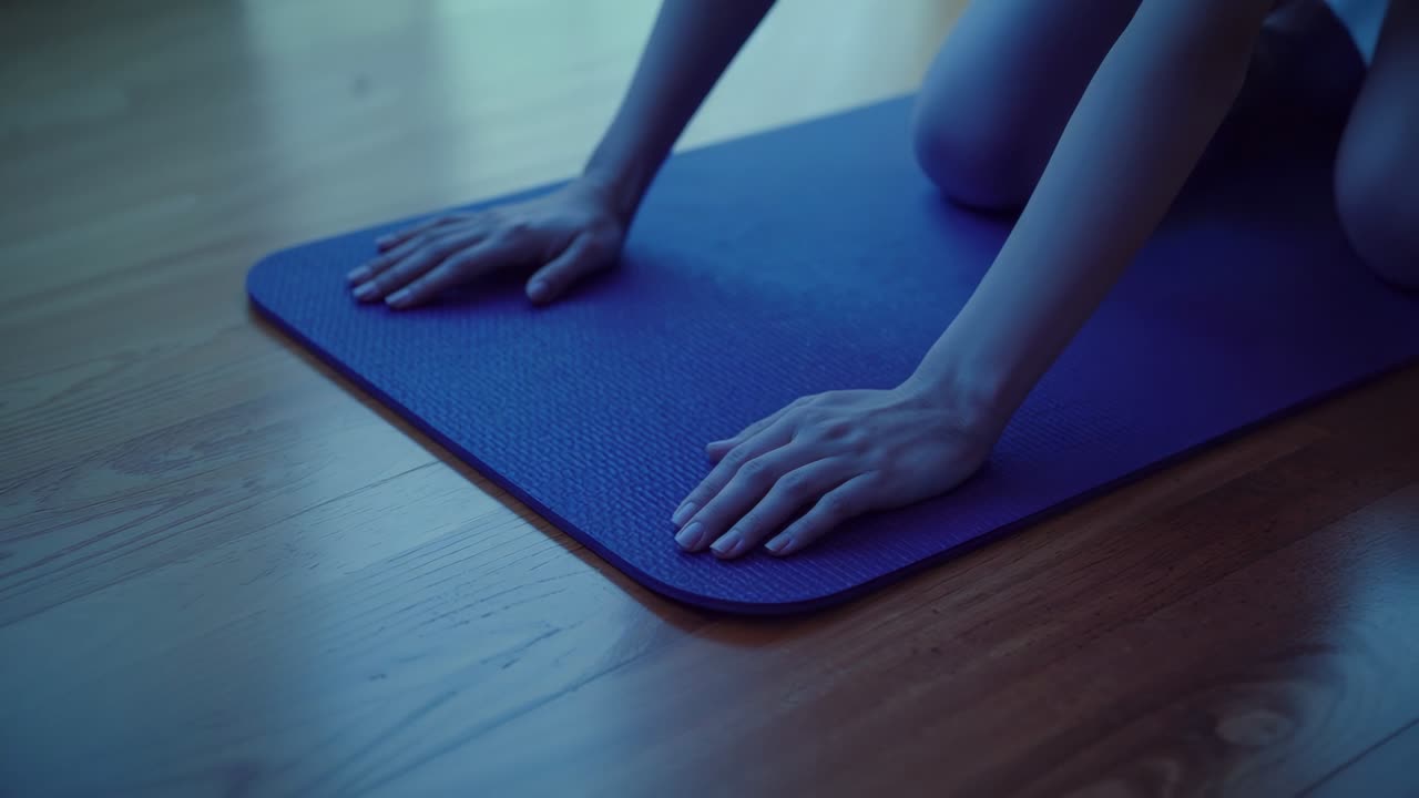 Starting exercise, adult female pressing hands onto blue yoga mat on wood floor, for stability