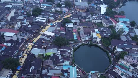 Drone-shot-of-crowd-of-Hindu-pilgrims-and-devotees-approaching-Kushavarta-Kund-to-take-holy-dip-during-the-month-of-Shravana,-Sacred-bathing-pond-near-Trimbakeshwar-temple,-Nashik,-Maharashtra,-India