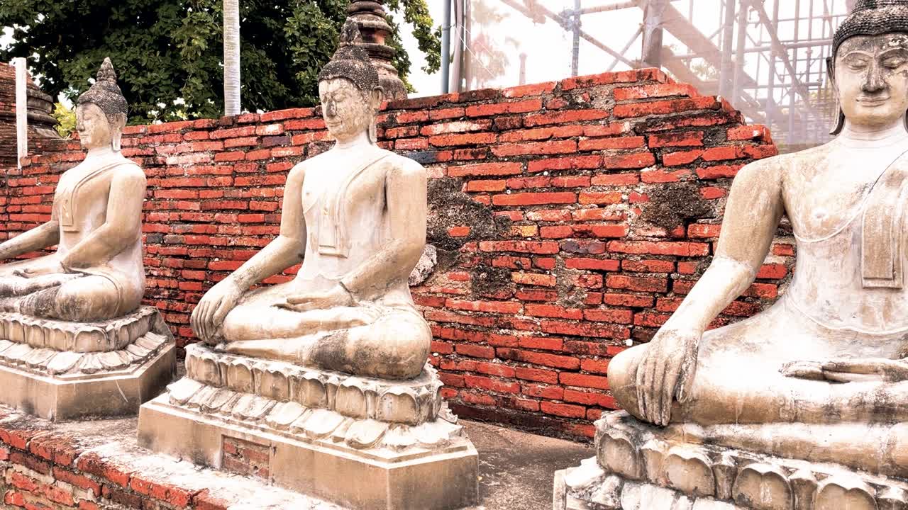 parque nacional histórico de ayutthaya en tailandia con estatuas budistas tailandesas a lo largo de una pared de ladrillo rojo