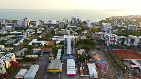 Drone-Aéreo-Con-Gran-Pintura-Humana-Al-Atardecer-En-La-Costa-Del-Distrito-Central-De-Negocios-De-Darwin,-Australia