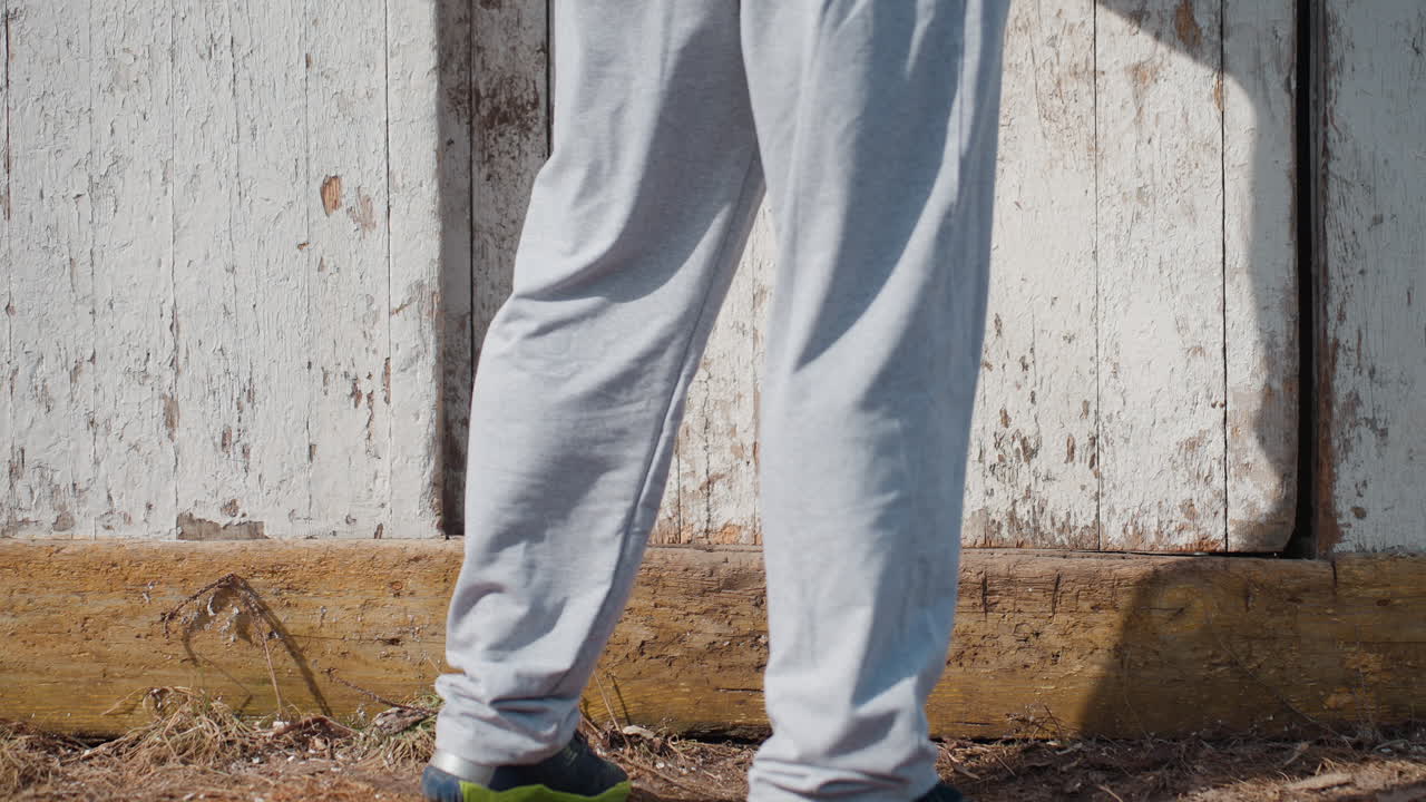 Pessoas passeando perto de um portão antigo, dupla de pedestres se movendo perto de uma entrada de madeira envelhecida durante o dia, dois civis caminhando ao longo de uma barreira de madeira vintage sob condições de luz clara