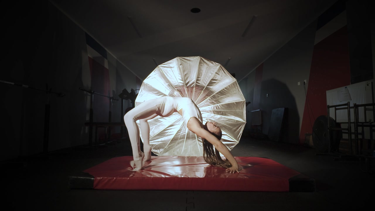 Acrobat in leotards practicing the handstand and side somersault