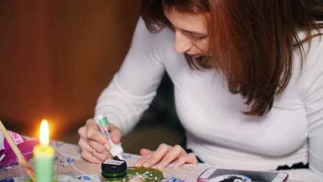 woman decorating a glass ornament
