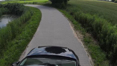 small car drives next to a lake