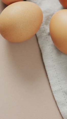 video of overhead view of eggs and on rustic cloth on beige background