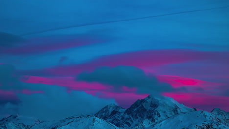 pink colored clouds moving behind the high mountains of tyrol