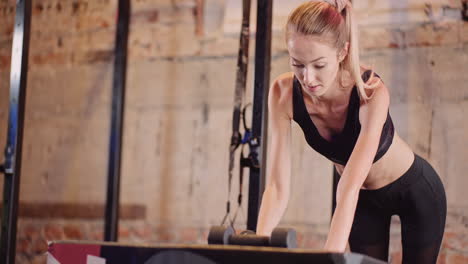 Determinado-Joven-Atleta-Femenina-Haciendo-Ejercicio-De-Fila-Con-Mancuernas-En-El-Gimnasio