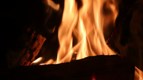 chimenea cerca de troncos de madera ardiendo con llamas