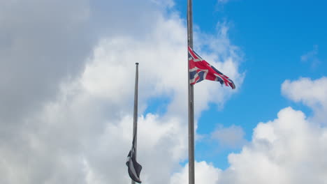 union jack flag and flag of cornwall at half-mast, official state of mourning after queen elizabeth ii's passing