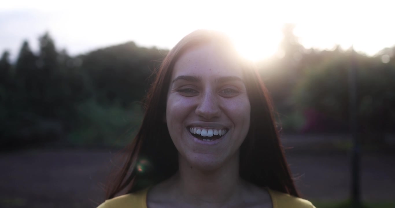Jovem Feliz Sorrindo ao Ar Livre com Brilho Solar