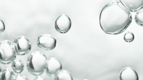 sidewards drifting transparent bubbles in low angle on white background