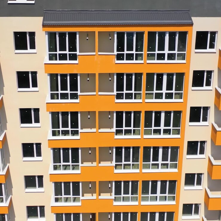 Fachada de arranha-céu recém-construído. Edifício moderno com paredes claras na cidade. Prédio alto com grandes janelas e varandas. Vista frontal.