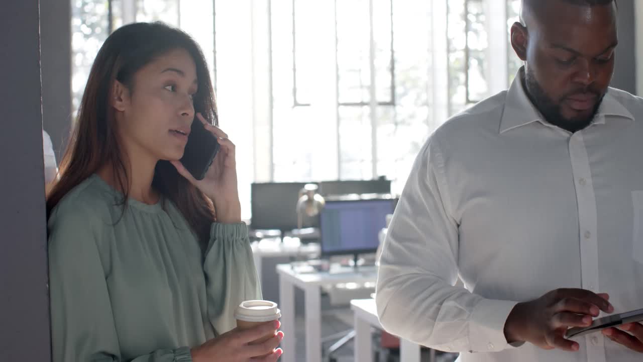 바쁜 다양한 동료들이 스마트폰으로 이야기하고, 태블릿과 노트북을 사용하여  ⁇ 은 사무실에서 느린 동작