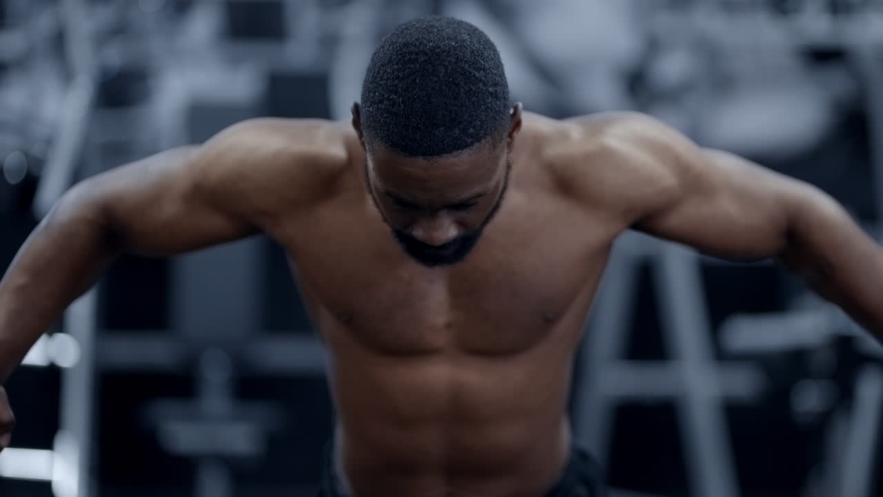 Muscular Atheltic African American doing Chest Fly exercise in gym