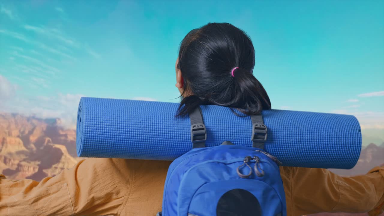 Close Up Back View Of A Female Hiker With Mountaineering Backpack Spreading Arms And Looking The View Around While Traveling At The Top Of Mountain