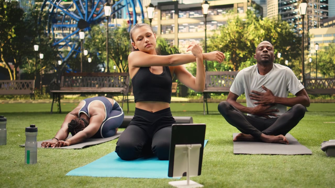 Woman participant performing seated stretching exercise on yoga mat