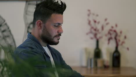 handsome bearded man using digital device in cafe