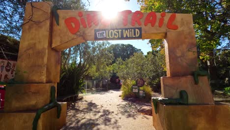 visitantes caminando por el sendero temático de los dinosaurios en el zoológico de melbourne
