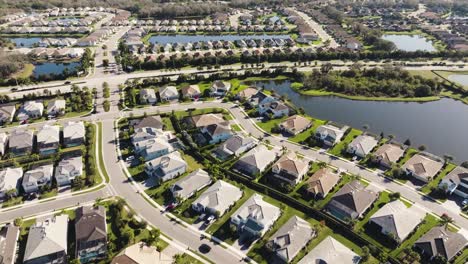 aerial of a sunny suburban neighborhood in tropical climate flying over hundreds of homes