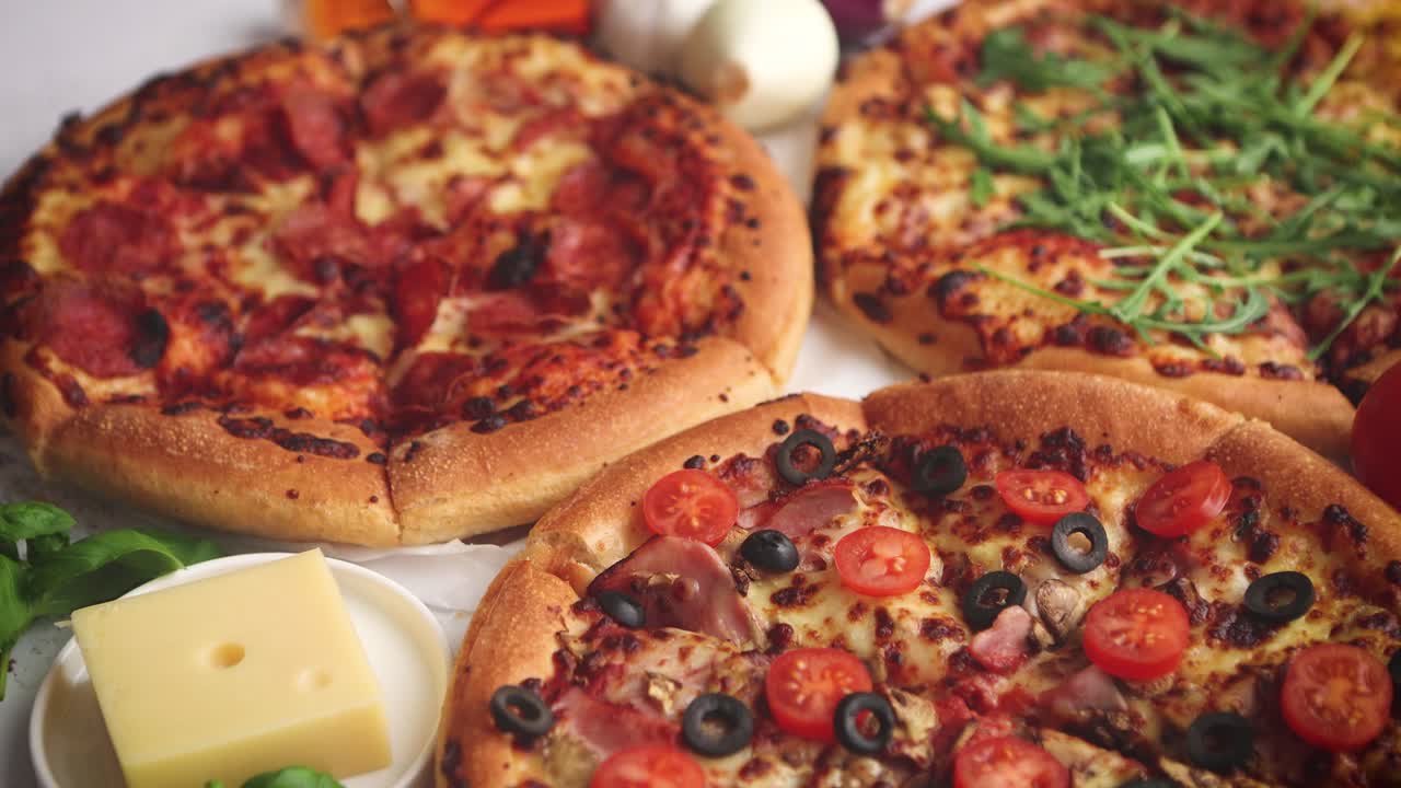Tre amerikanske pizzaer serveret på et bord
