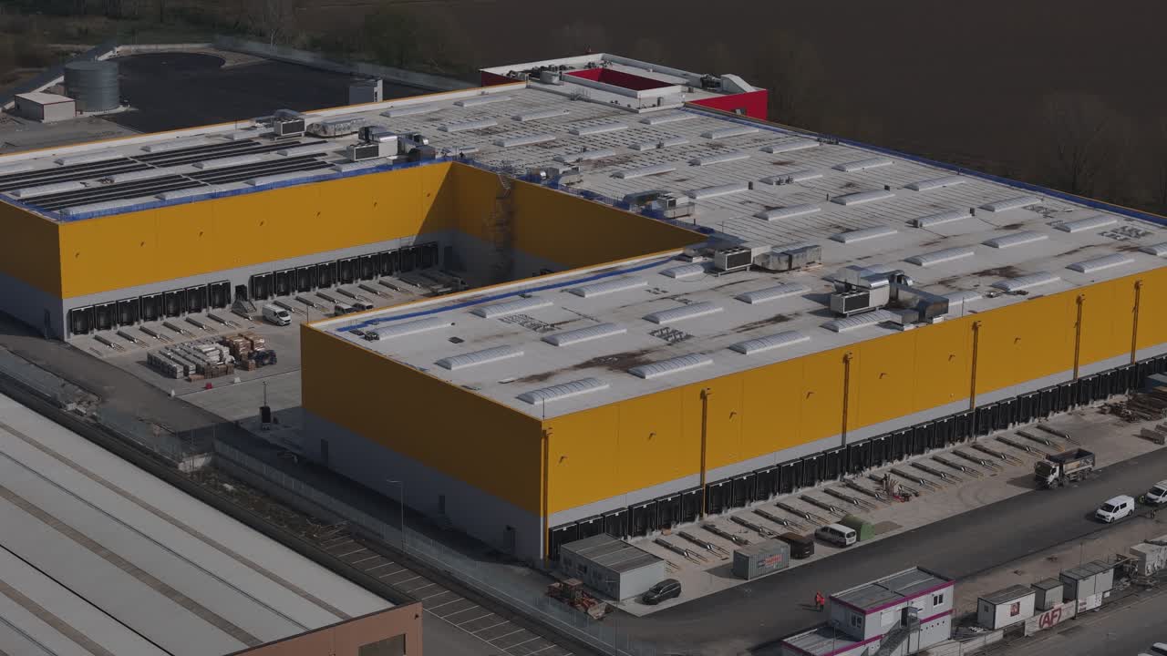 Logistics warehouse in Pontenure Piacenza Emilia Romagna Italy with loading docks, truck bays and distribution infrastructure within Po Valley industrial hub, drone establishing shot