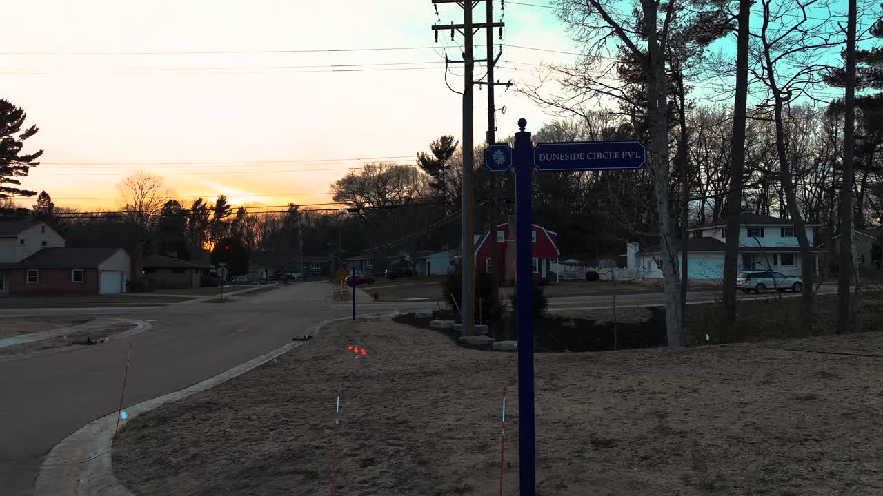 새 표지판으로 길을 가로지르는 해가 지고