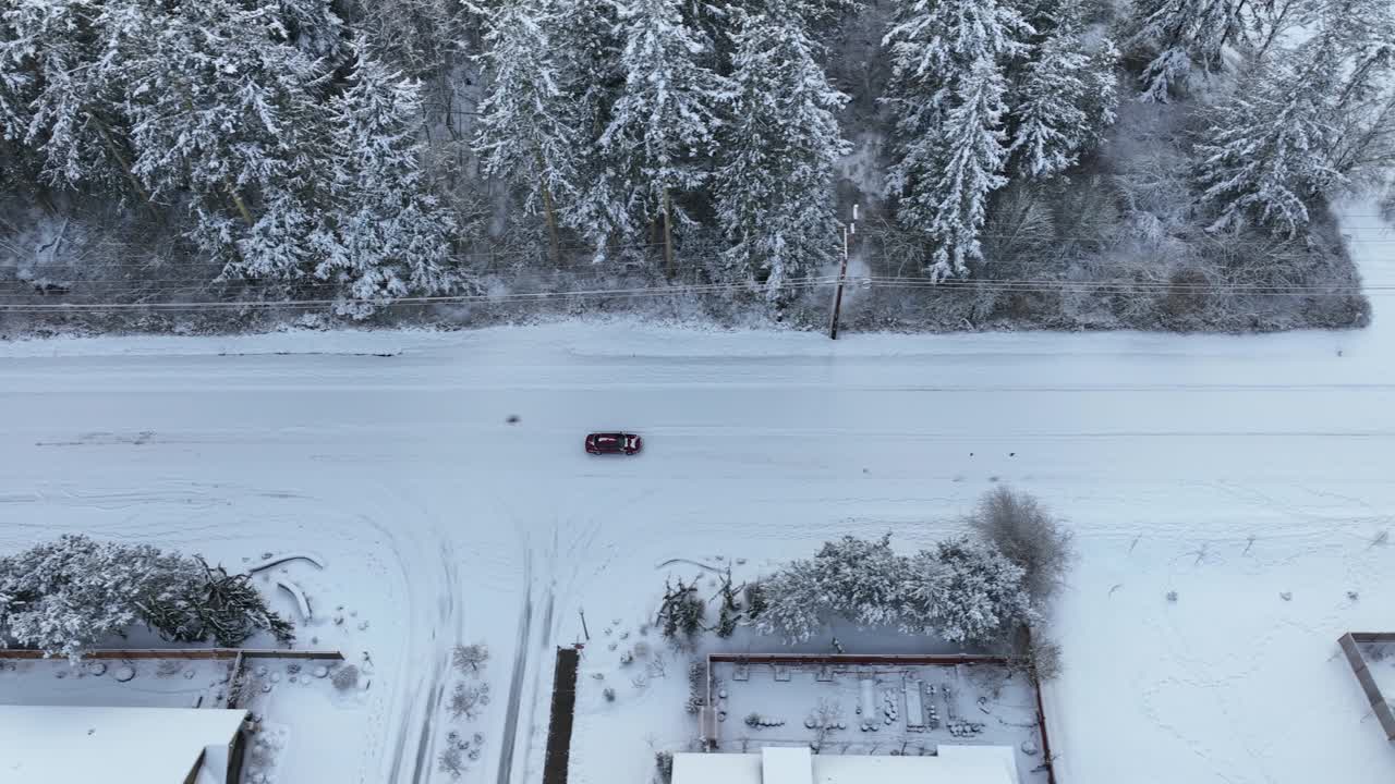 vista aérea de un coche conduciendo con cuidado sobre nieve fresca