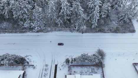 Vista-Aérea-De-Un-Coche-Conduciendo-Con-Cuidado-Sobre-Nieve-Fresca