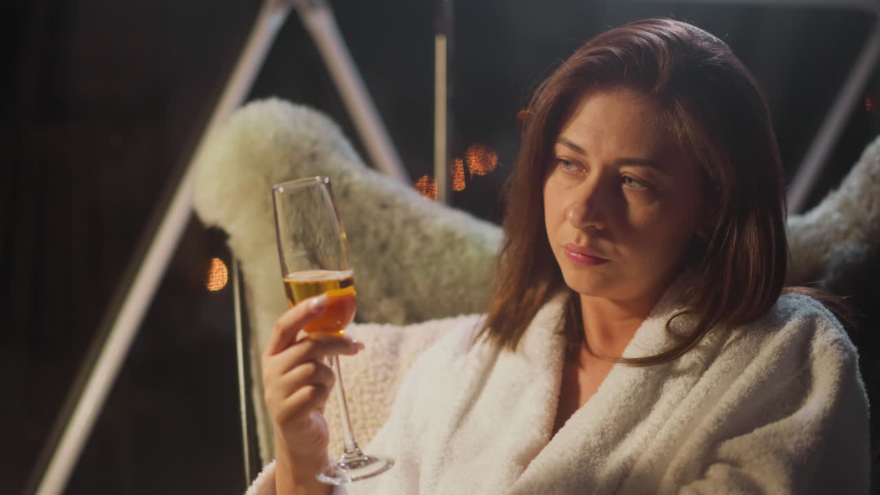 mujer sombría con expresión triste en el rostro bebe champán en una copa sola relajándose en una casa de campo para turistas depresión en la edad adulta y problemas de salud mental