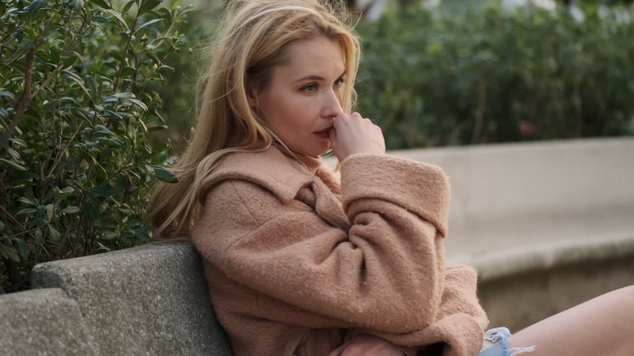 도시 공원에서 앉아있는 젊은 여성.