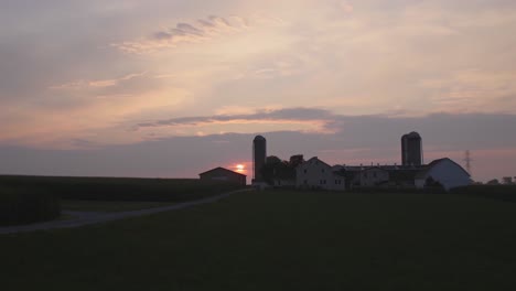 sunrise over amish farmlands with a colorful sky on a misty summer morning timelapse