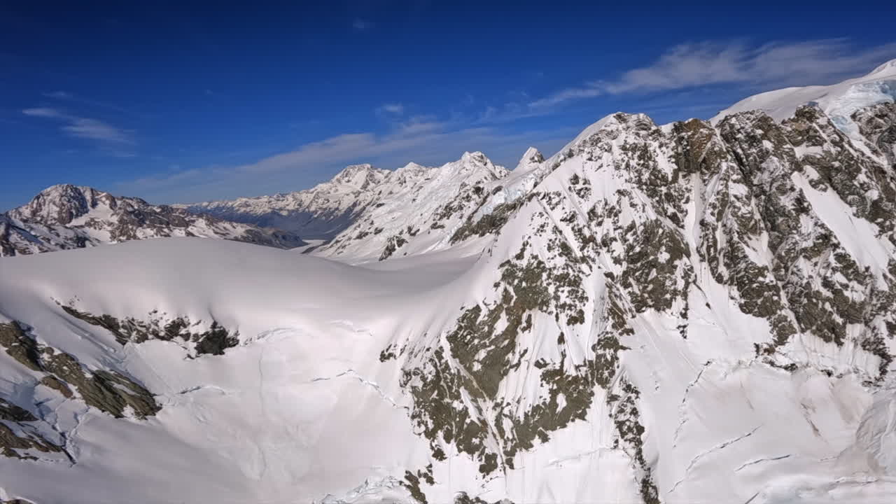 POV flying between the peaks of snowcapped mountains in the Southern Alps of New Zealand
