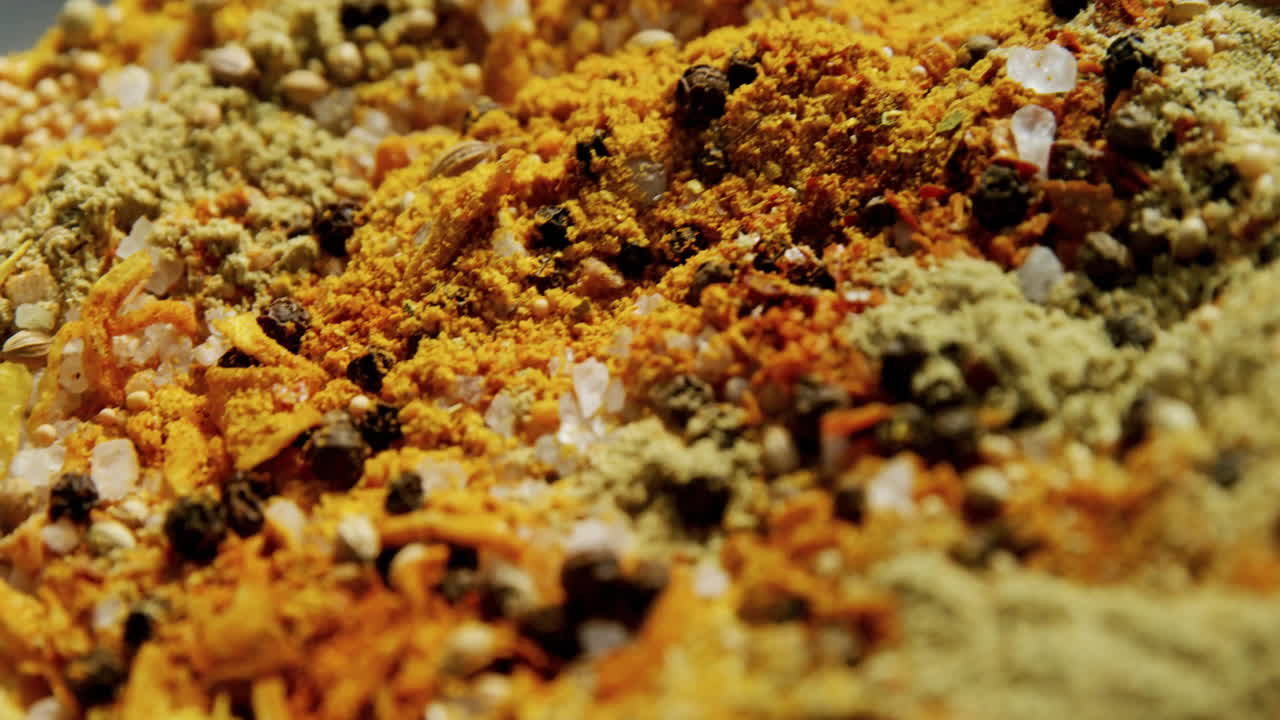 Close-up showing various colorful spices, animated and moving in vibrant display