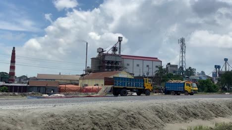 industrial factory with chimney and parked machines, drive by view