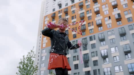 little girl playing with bubbles in a city park