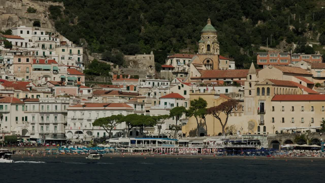 pov desde un barco navegando en el mar con la ciudad de amalfi, la catedral y la playa en italia