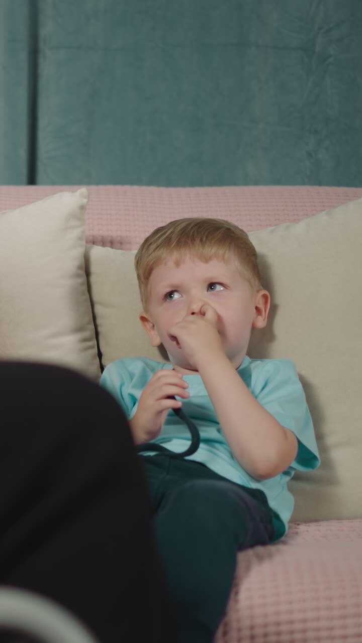 Preschooler and toddler listen to mother with paralysis reading fairytale in evening. Woman sits in wheelchair entertaining children at home closeup