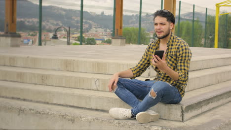 chico guapo usando teléfono celular en un parque