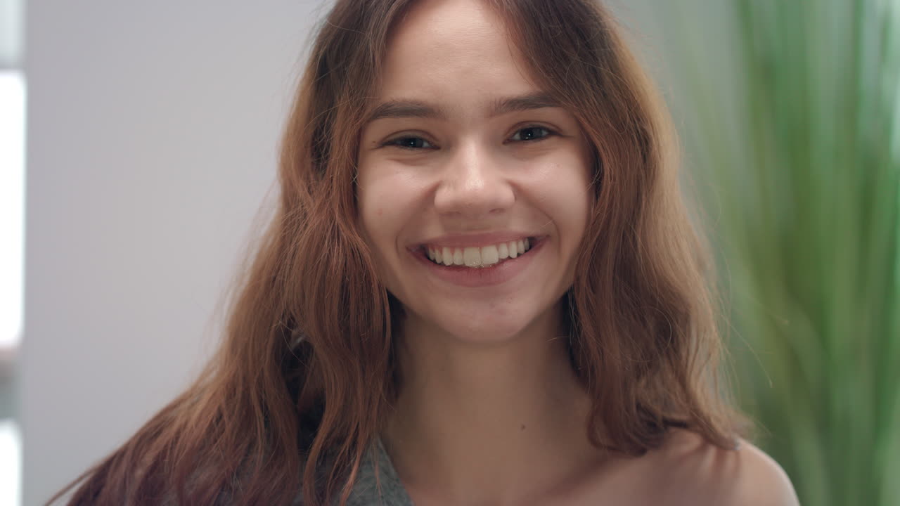 retrato de una mujer sonriente lamiendo la lengua a los dientes blancos espejo delantero en el baño