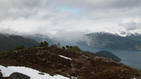 Norwegian-fjord-with-dramatic-clouds-surrounding-mountain-peaks-at-the-west-coast-of-Norway-at-Sunnmøre,-Liavarden