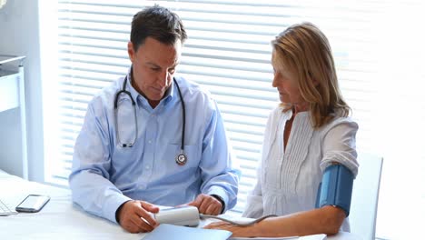 el médico interactuando con el paciente mientras controla la presión arterial